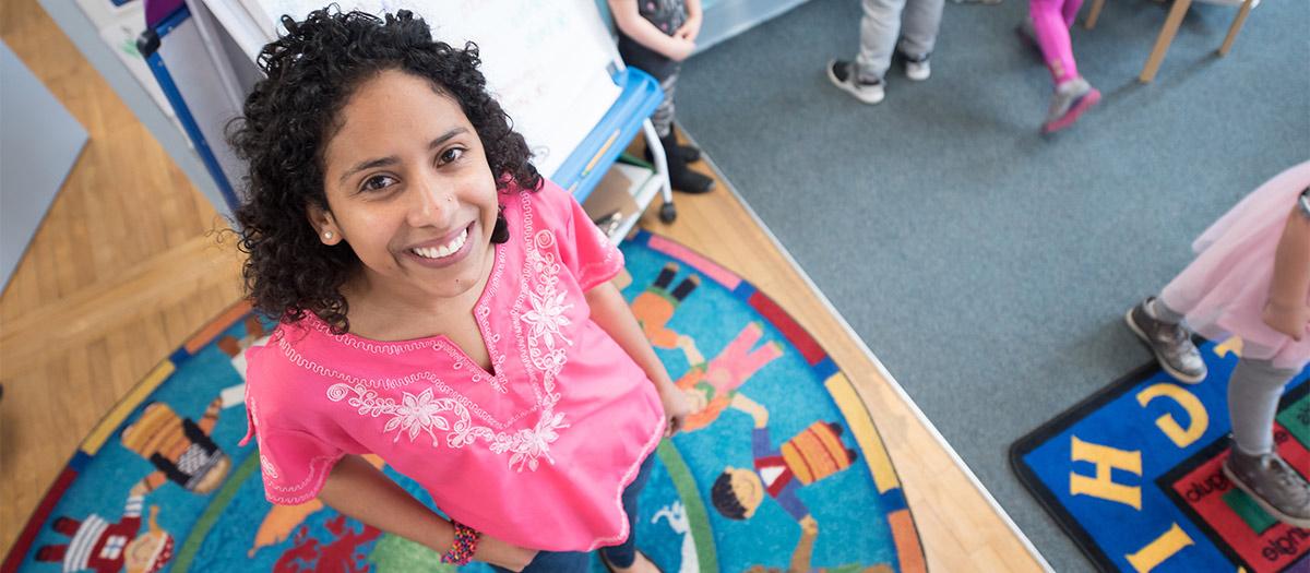 Luz Anaheli Stegner stands on a rug in her kindergarten classroom.